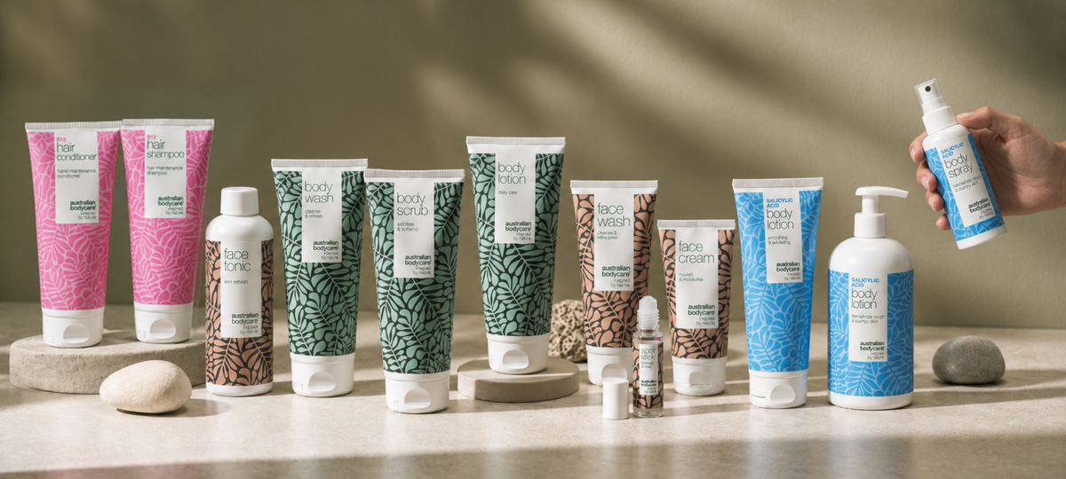 Produktový rad Australian Bodycare na svetlom kamennom povrchu: B12 Hair Shampoo a Conditioner v ružovej, Face Tonic, Face Wash a Face Cream v béžovej, Body Wash, Body Scrub a Body Lotion v zelenej a Salicylic Acid Body Lotion a Body Spray v modrej.