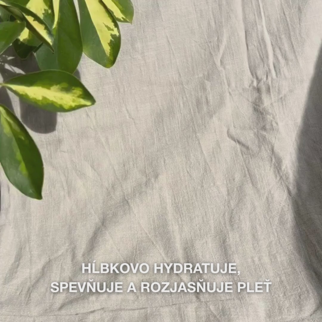 Záber zblízka na ženu, ktorá nanáša sýtoružovú pleťovú masku s vitamínom B12 a kolagénom na čistú pokožku: rozotiera ju po lícach, čele a brade, zatiaľ čo kolagén a B12 hydratujú, spevňujú, upokojujú pokožku a dodávajú jej žiarivý vzhľad.