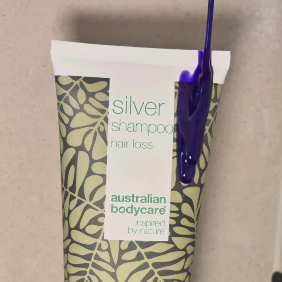 Video zobrazujúce náš Hair Loss Silver Shampoo so strieborno-fialovým odtieňom nanášaný na mokré vlasy v sprche.