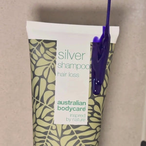 Video zobrazujúce náš Hair Loss Silver Shampoo so strieborno-fialovým odtieňom nanášaný na mokré vlasy v sprche.
