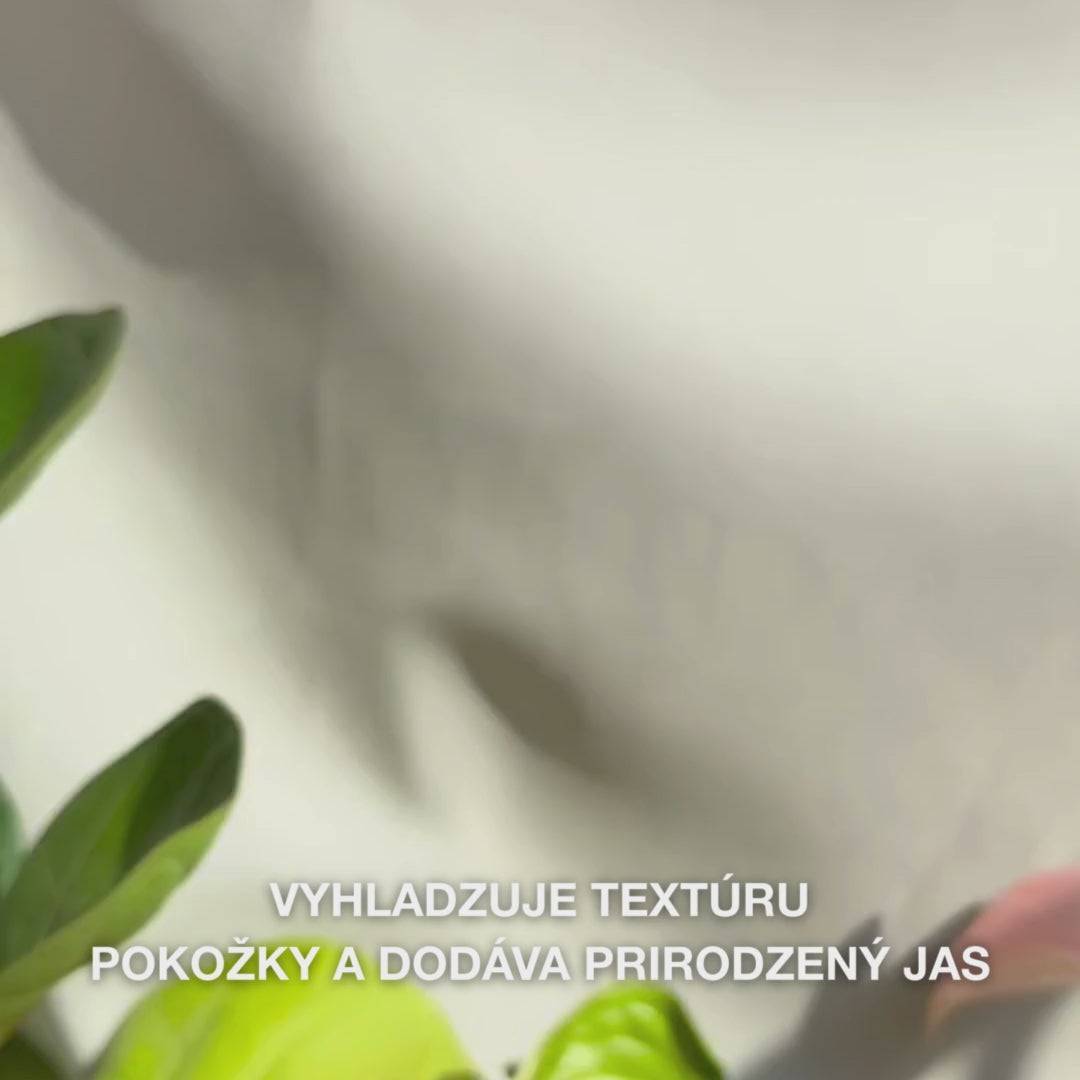 Detail ruky, ktorá nanáša niekoľko tenkých kvapiek priehľadného, ľahkého Peeling Serumu na končeky prstov a jemne ho vmasíruje do čistej pokožky tváre — hodvábna, tekutá konzistencia viditeľne rozpúšťa odumreté bunky, zjemňuje štruktúru pokožky a zvýrazňuje žiarivosť pomocou prírodných AHA (Lime Pearl), niacinamidu a tea tree oleja 